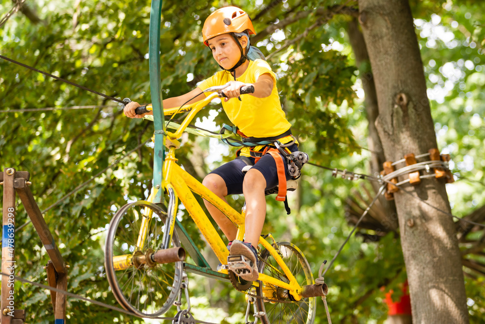 Adorable little girl enjoying her time in climbing adventure park on warm and sunny summer day Adorable little girl enjoying her time in climbing adventure park on warm and sunny summer day