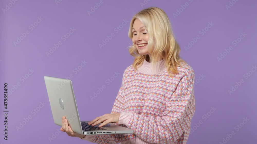Excited happy satisfied elderly blonde woman lady 40s years old wears warm shirt hold use work point index finger on laptop pc computer isolated on plain pastel light purple background studio portrait Excited happy satisfied elderly blonde woman lady 40s years old wears warm shirt hold use work point index finger on laptop pc computer isolated on plain pastel light purple background studio portrait