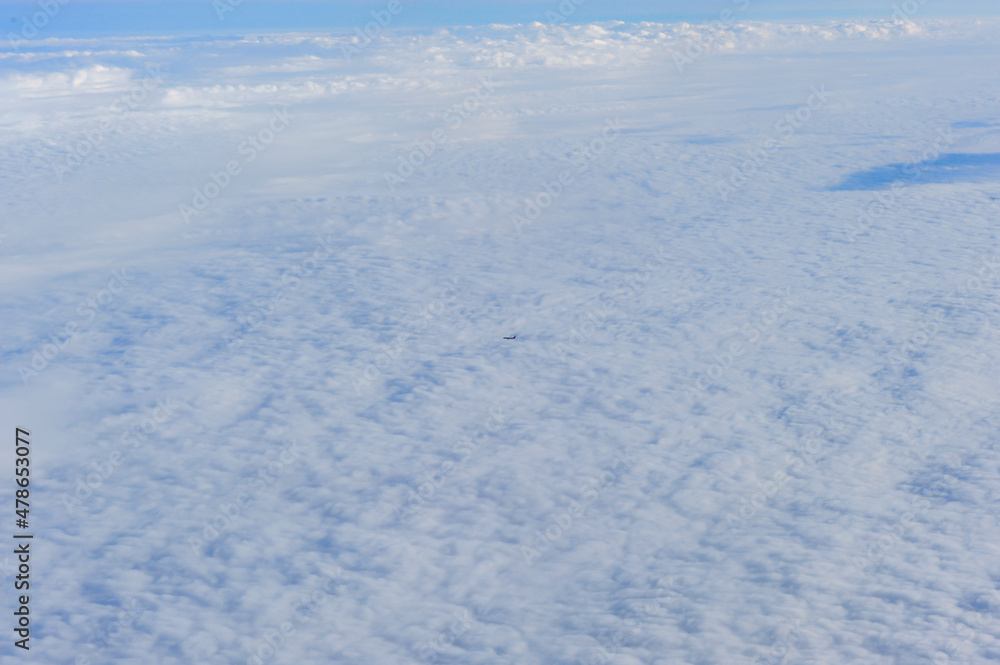 The beautiful scenery of the sea of clouds and the earth through the suspended window on the plane