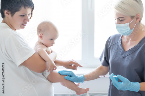 The doctor makes a baby vaccination on a white background.