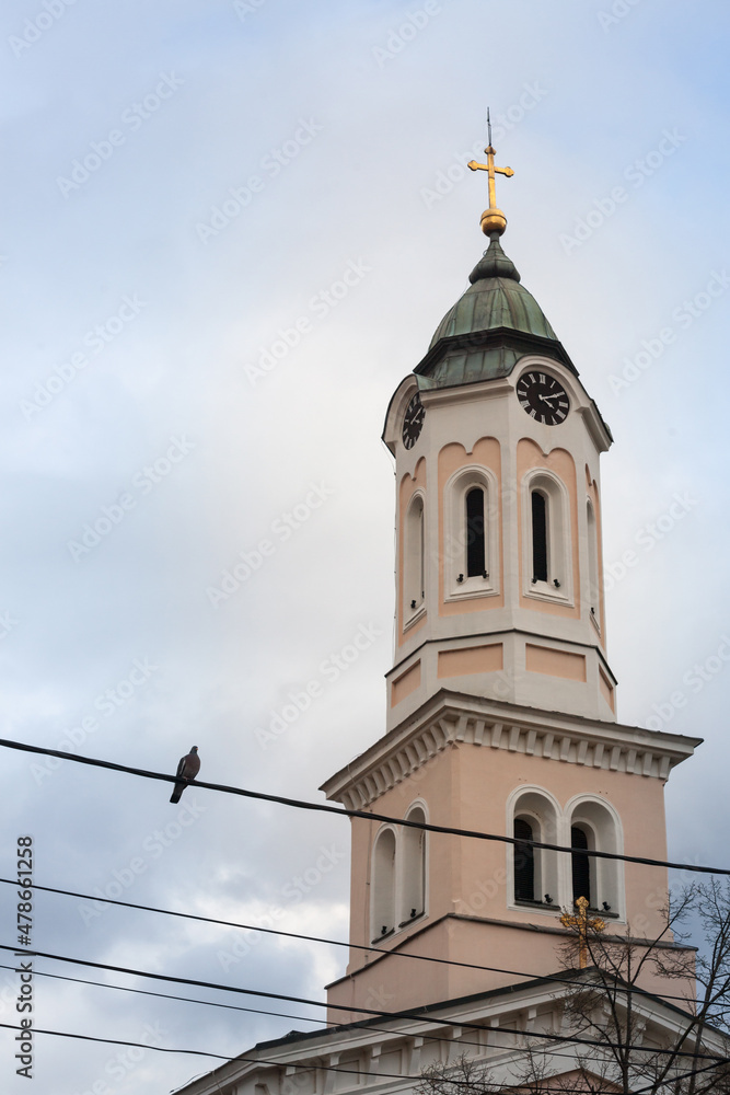 Close up on Church clocktower steeple of the serbian orthodox church of Crkva svetog duha, church of the holy spirit, in Obrenovac, Serbia with its iconic clock indicating the time. ...