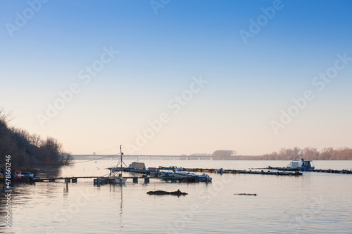Boats & ships, fishing ships and boats  tanding anchored on the riverbanks of the river Dabubein Zemun, a suburb of Belgrade, Serbia during a sunny afternoon with a bridge behind... © Jerome