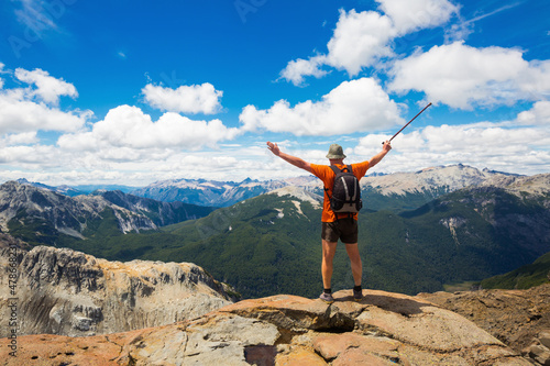 Fototapeta Naklejka Na Ścianę i Meble -  Traveler enjoying hilltop mountain views with green trees and shrubs