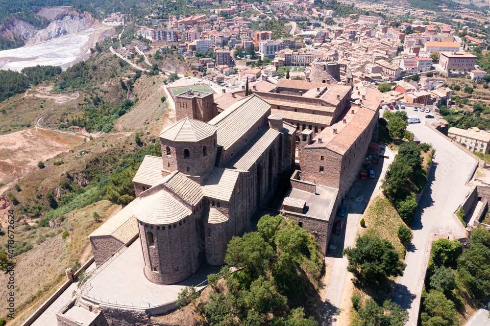 Aerial view of ancient fortified castle complex of Cardona on hill dominating residential areas of town on sunny summer day, Spain