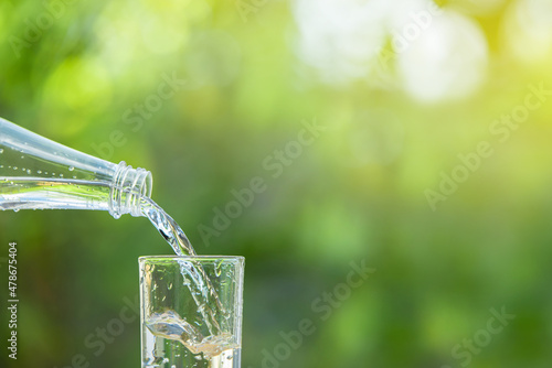 Pour the clean water from the water bottle into the glass.