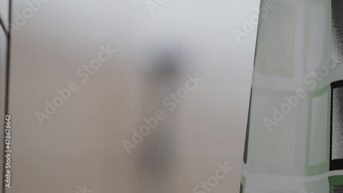 Shower room in hotel or hostel or hospital. Decorative printed plastic curtain in a bathroom with white tiled walls. Room for bathing and taking a shower. Moving slowly. Home interior details. Nobody