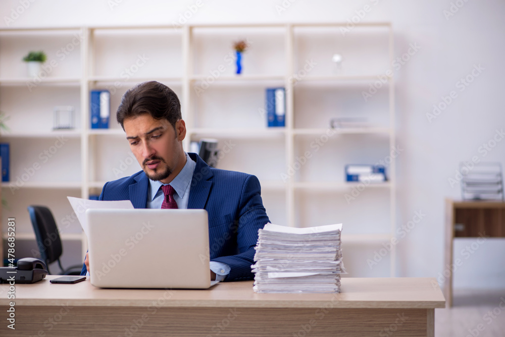 Young businessman employee and too much work in the office Young businessman employee and too much work in the office