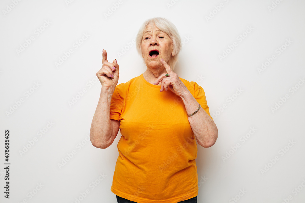 Portrait of an old friendly woman in casual t-shirt gestures with his hands cropped view Portrait of an old friendly woman in casual t-shirt gestures with his hands cropped view