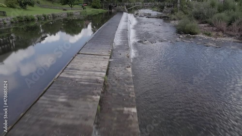 Wallpaper Mural Close-up drone video of a frontal bird view on the bathing platform in the Pûstal village pond with the bridge in the background and the waterfall in Slovenia. Torontodigital.ca