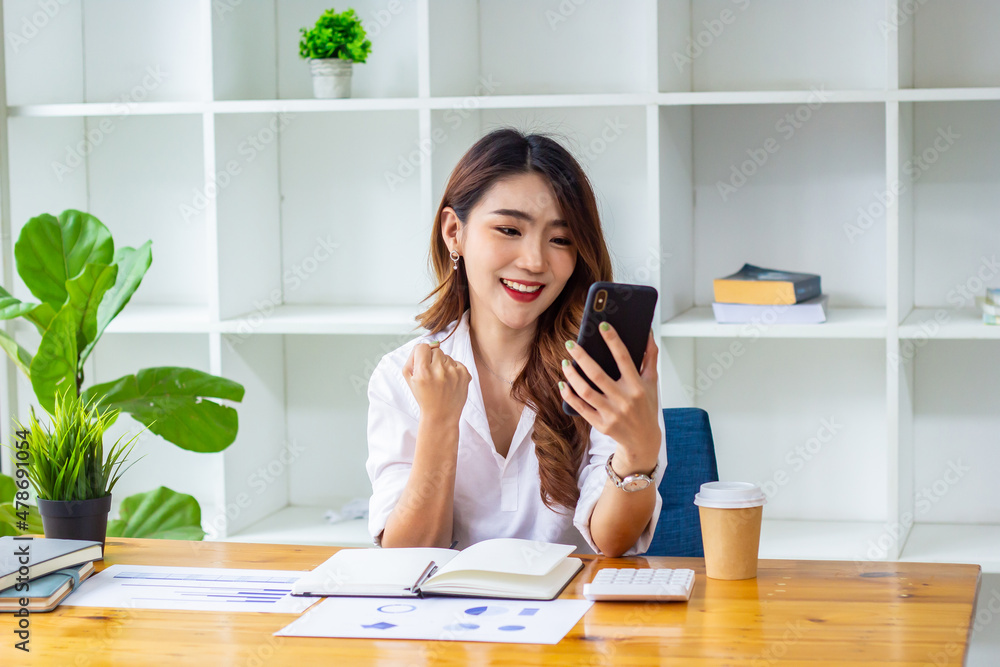 Businesswoman looking at last year's company sales data on the phone, woman sitting in a chair looking at financial documents, accountant checking company numbers, new business concept. Businesswoman looking at last year's company sales data on the phone, woman sitting in a chair looking at financial documents, accountant checking company numbers, new business concept.