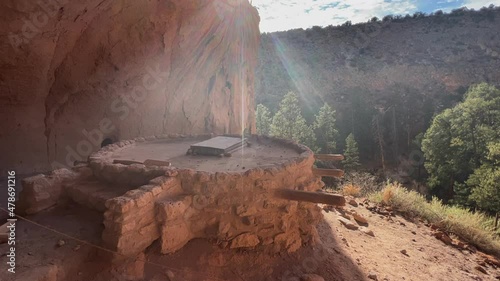 Ancient indigenous Kiva built in rock cliff shadow in New Mexico photo