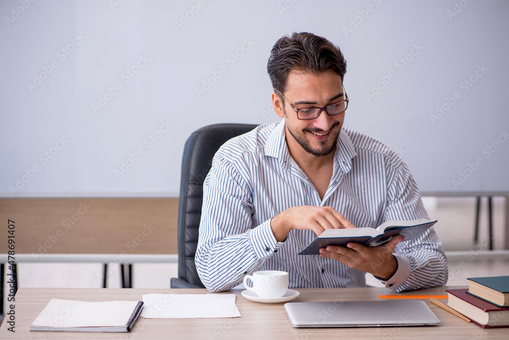 Young male teacher in the classroom Young male teacher in the classroom