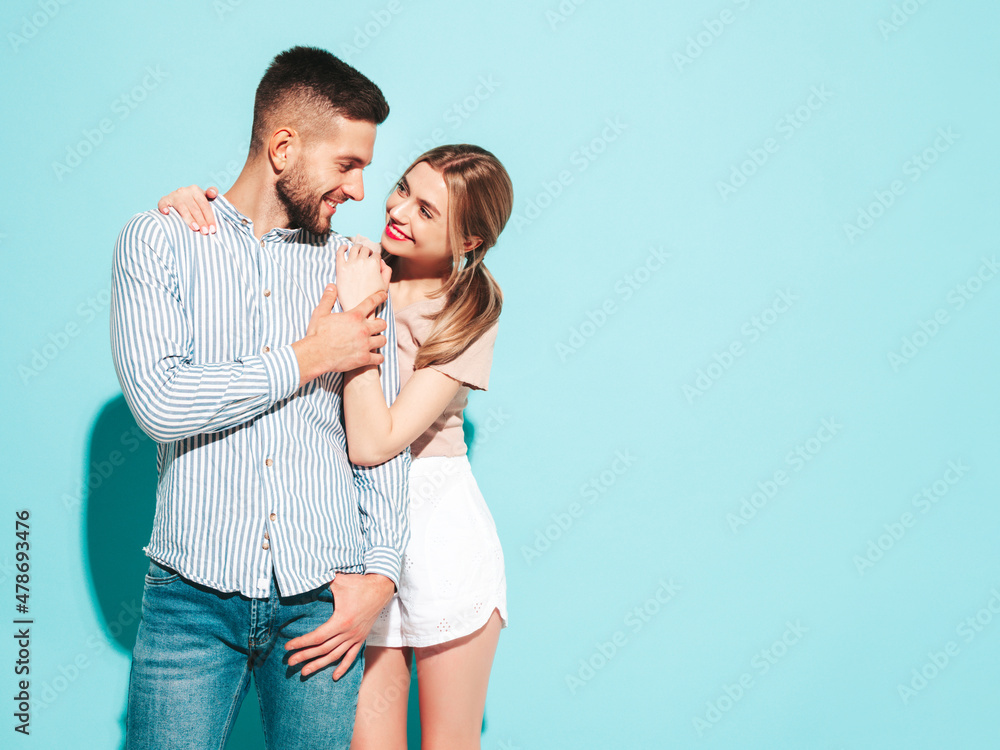 Sexy smiling beautiful woman and her handsome boyfriend. Happy cheerful family having tender moments near blue wall in studio.Pure cheerful models hugging.Embracing each other Sexy smiling beautiful woman and her handsome boyfriend. Happy cheerful family having tender moments near blue wall in studio.Pure cheerful models hugging.Embracing each other