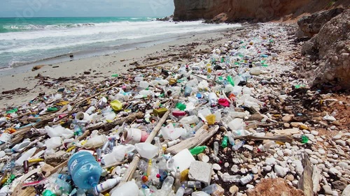 Ocean pollution with plastic waste. Sea beach with ecological garbage. The global problem of the death of marine plants and animals. photo
