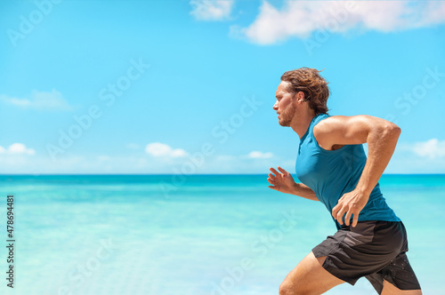 Obraz na plátně Athlete man runner training cardio running fast sprinting during beach workout running profile portrait