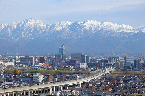雪化粧した山と市街地の風景