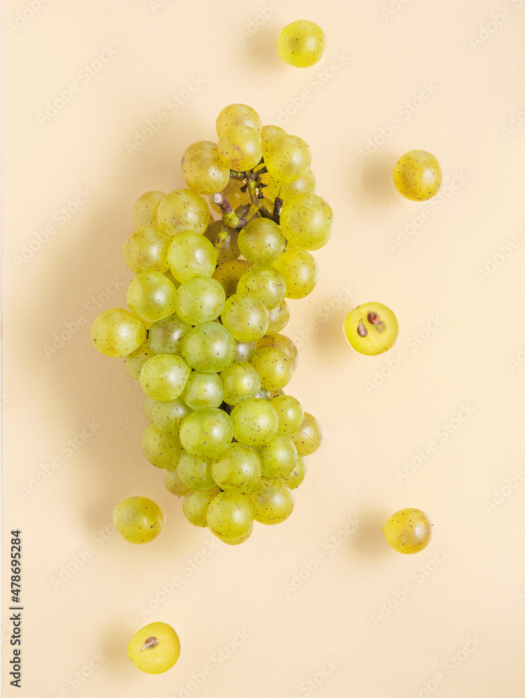 Beautiful grape lie on  yellow pastel background. Nature fruit minimalism.