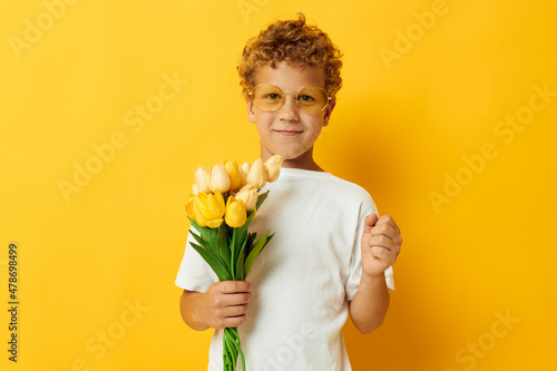 Photo portrait curly little boy with yellow flowers posing childhood fun isolated background unaltered