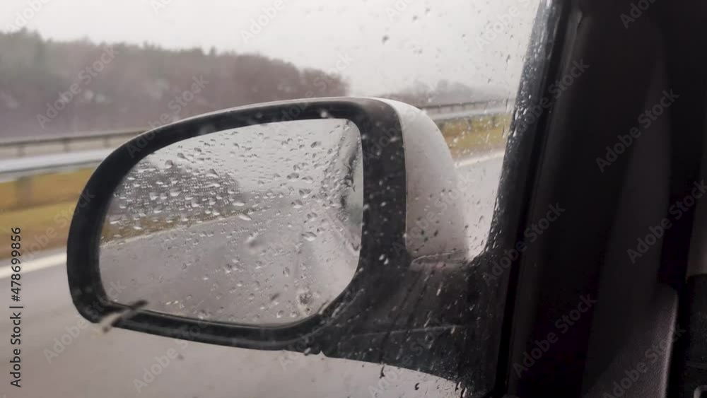 View car side mirror at rain. Raindrops on car side. Traveling in bad wet weather. View car side mirror at rain. Raindrops on car side. Traveling in bad wet weather.