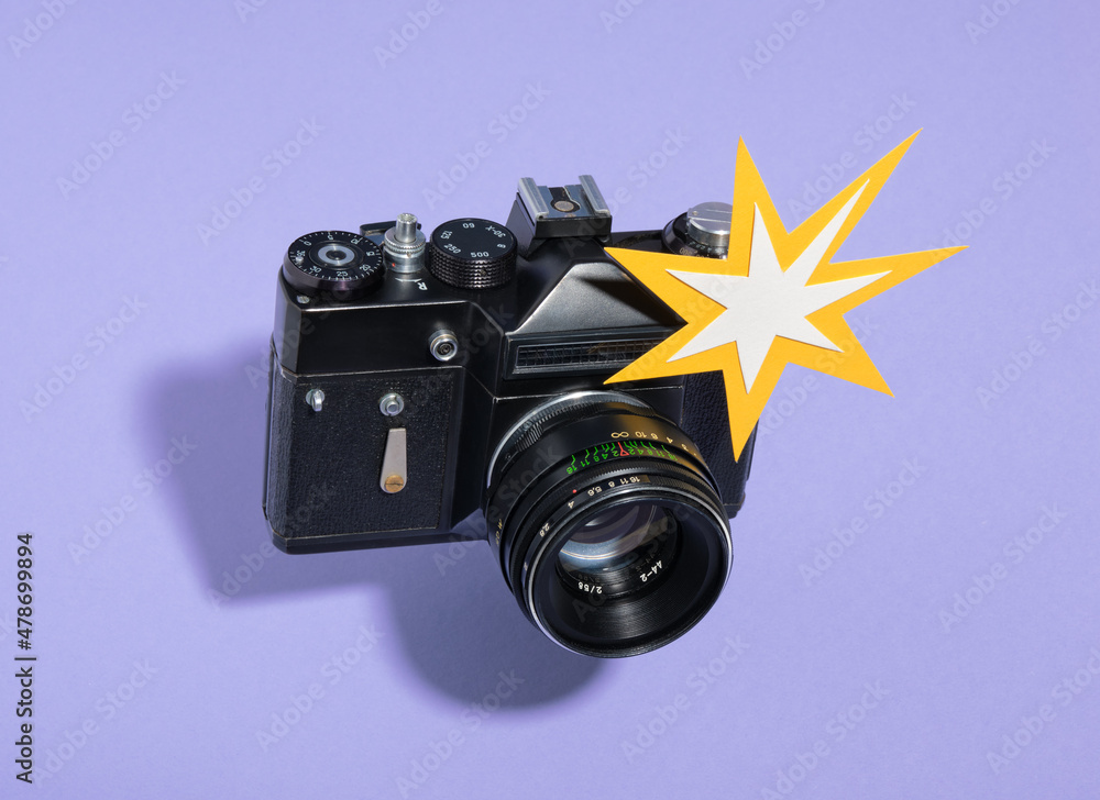 Retro film photo camera takes a photo and flash appears. Creative work ...