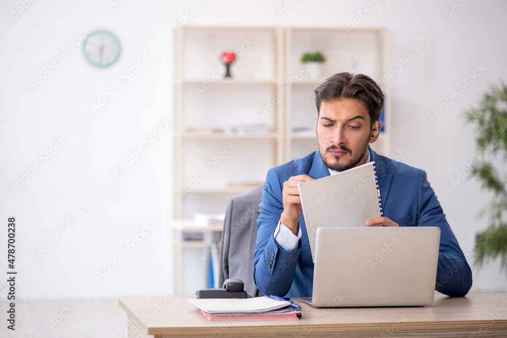 Deaf male employee using hearing aid at workplace Deaf male employee using hearing aid at workplace