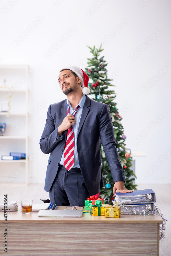 Young male employee celebrating Christmas at workplace Young male employee celebrating Christmas at workplace