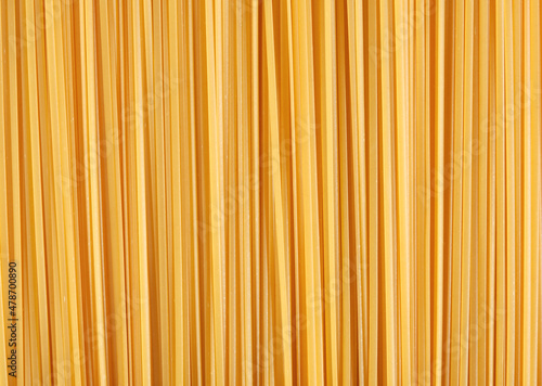 Flat lay composition of smooth amber yellow pasta. Source of carbohydrates and vitamins. In combination with fish, meat and vegetables it is valuable dietary product.