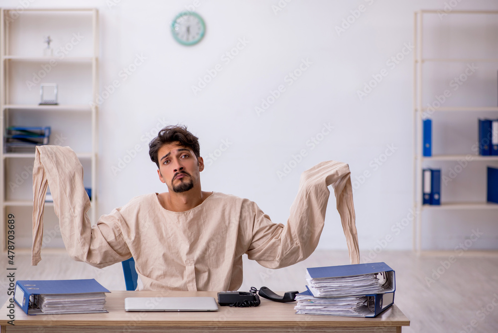 Crazy young man in straitjacket at the office Crazy young man in straitjacket at the office