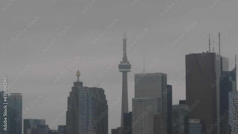 Toronto CN tower and cityscape in fog - foggy weather in the capital city of Ontario, Canada - buildings and sky scrapers covered in fog Toronto CN tower and cityscape in fog - foggy weather in the capital city of Ontario, Canada - buildings and sky scrapers covered in fog