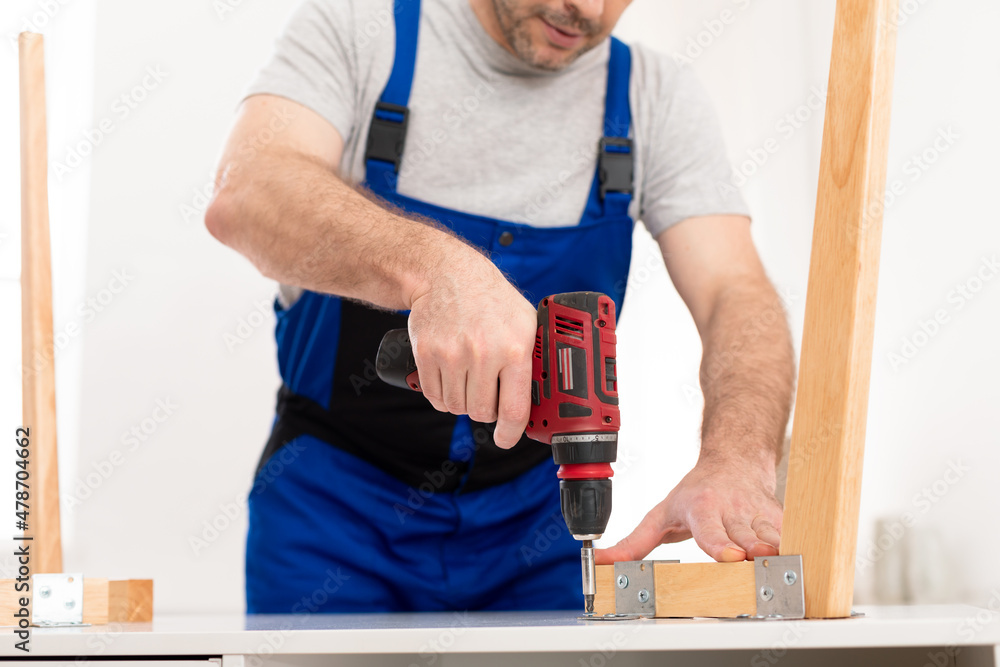 Cropped Shot Of Professional Carpenter Using Drill Assembling Table Indoor Cropped Shot Of Professional Carpenter Using Drill Assembling Table Indoor
