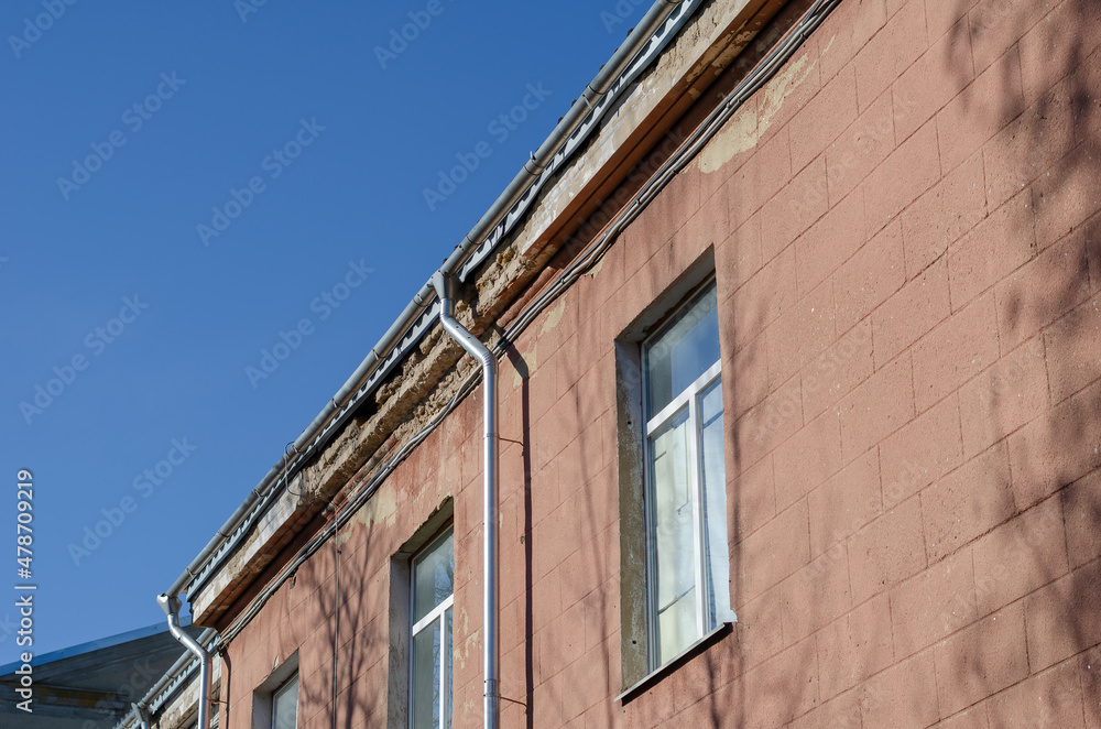 Obraz premium The top of the emergency building. Collapsing plaster on the fac