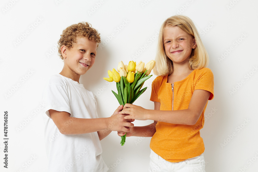 picture of positive boy and girl holiday friendship with a gift Yellow flowers light background