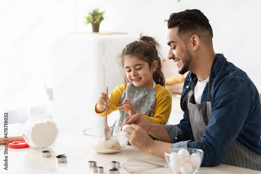 Little Arab Girl Baking With Father In Kitchen, Preparing Dough For Cookies Little Arab Girl Baking With Father In Kitchen, Preparing Dough For Cookies