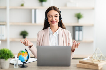 Manager Lady Video Calling Talking To Laptop Wearing Headset Indoors