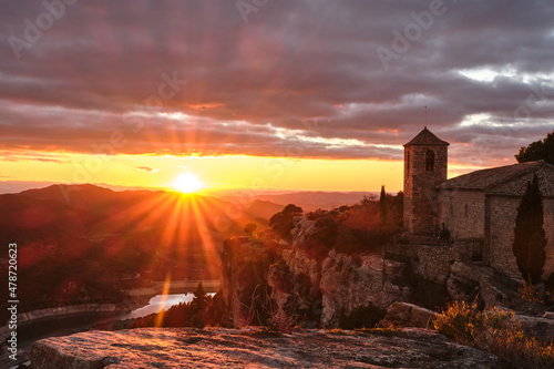 View of the Romanesque church of Santa Maria de Siurana on the cliff at sunset, Siurana, Tarragona, Catalonia photo