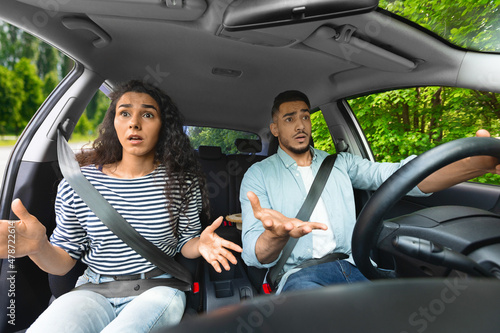 Indignant middle-eastern young couple having car accident