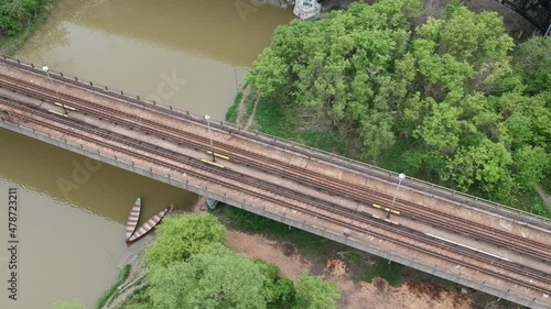 Drone Rise over River with two canoes under Subway Train bridge beside vehicle bridge photo