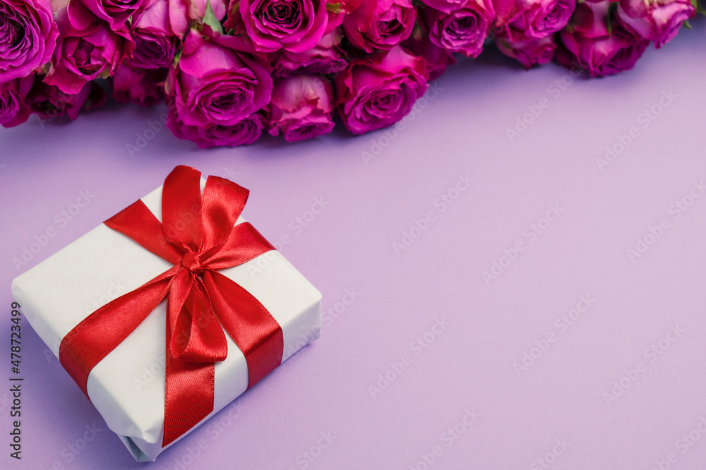 Gift box and flowers on color background with space for text Gift box and flowers on color background with space for text