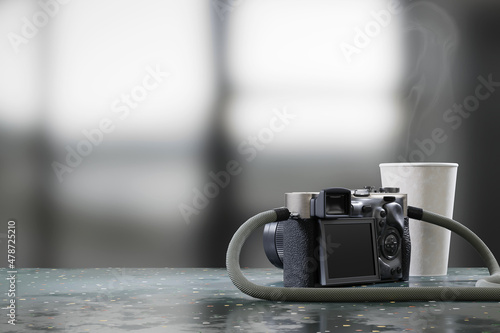 Camera and coffee cup placed on table with blurred background 3d rendering