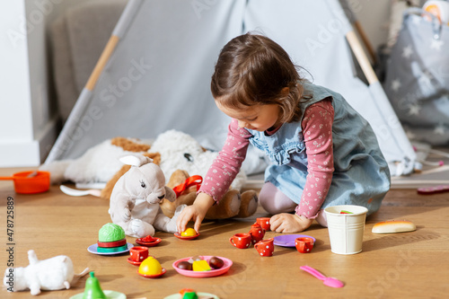 Fotografi childhood, leisure and people concept - happy little baby girl playing with tea