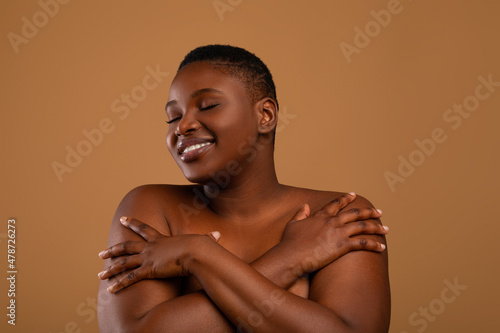 Portrait of beautiful plus size African american woman embracing herself