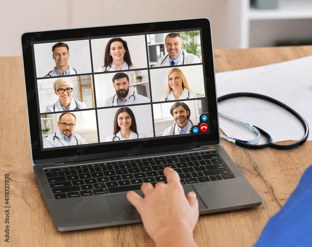 Doctor Video Calling Communicating With Group Of Colleagues Indoor, Cropped Doctor Video Calling Communicating With Group Of Colleagues Indoor, Cropped