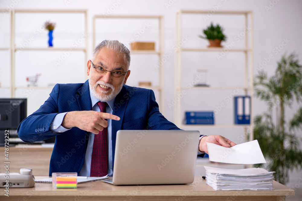 Old male employee working in the office Old male employee working in the office