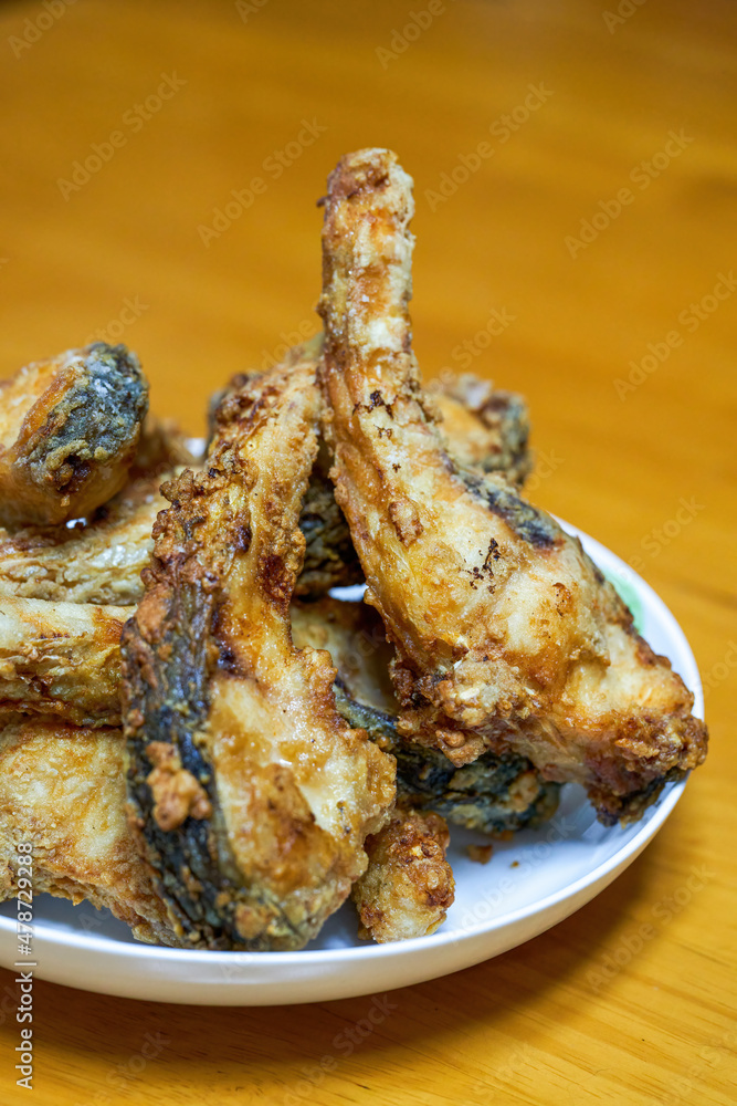 A plate of delicious fried grass carp belly closeup A plate of delicious fried grass carp belly closeup