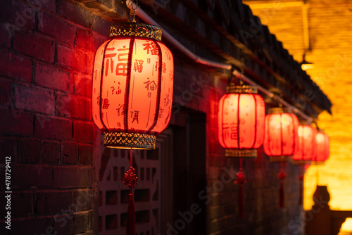 Under the eaves of the ancient city wall, lanterns with Chinese blessings are hung