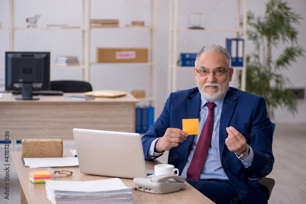 Old male employee working in the office Old male employee working in the office