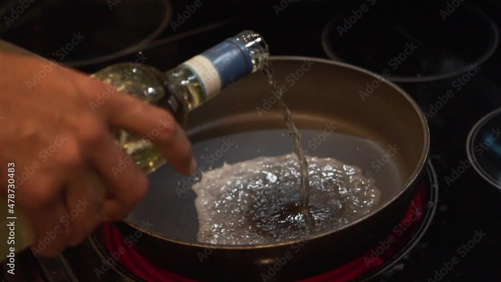 Slow Motion zooming shot of Cooking wine being poured into a hot frying pan in HD 1080p 23 Slow Motion zooming shot of Cooking wine being poured into a hot frying pan in HD 1080p 23