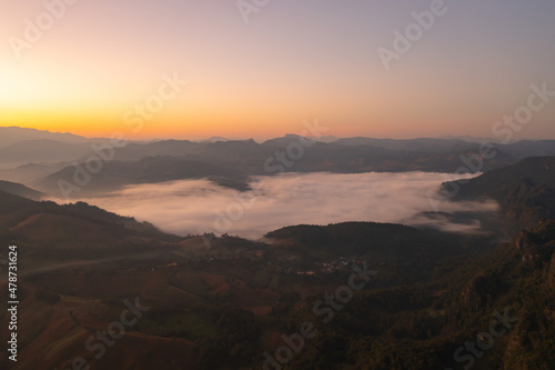Aerial top view of forest trees and green mountain hills with sea fog  mist and clouds. Nature landscape background  Thailand.