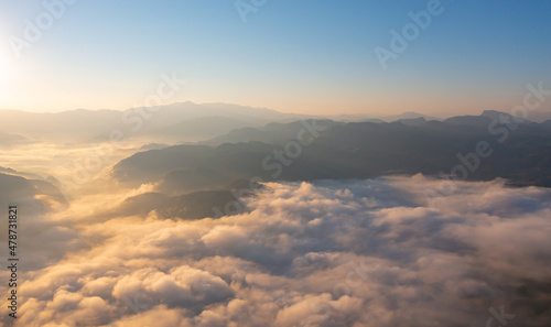 Aerial top view of forest trees and green mountain hills with sea fog  mist and clouds. Nature landscape background  Thailand.