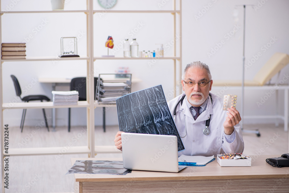 Old male doctor radiologist working in the clinic Old male doctor radiologist working in the clinic